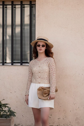a lady in a brown lace top and a pair of white shorts